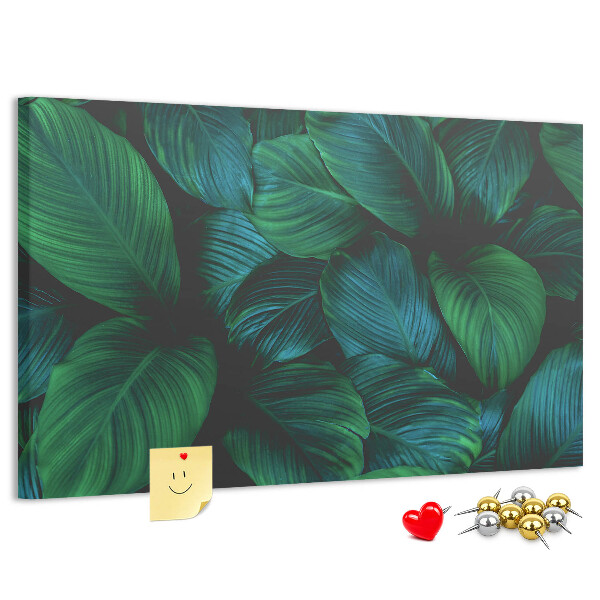 Pizarra de corcho con diseño de hojas tropicales sobre fondo oscuro