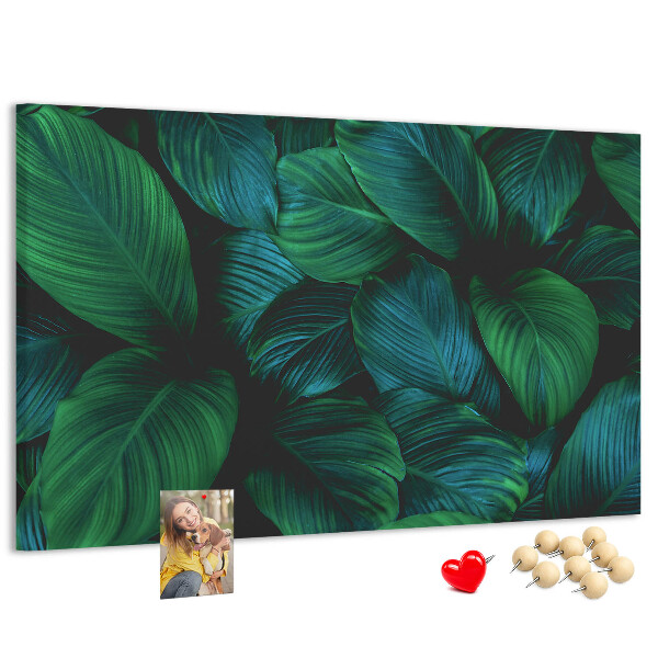 Pizarra de corcho con diseño de hojas tropicales sobre fondo oscuro