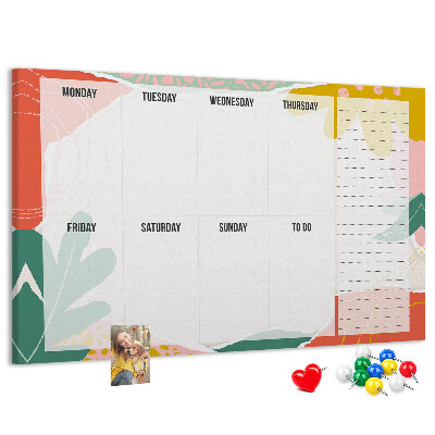 Tablero de corcho decorado con diseño de calendario floral y detalles coloridos