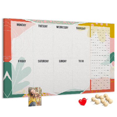 Tablero de corcho decorado con diseño de calendario floral y detalles coloridos