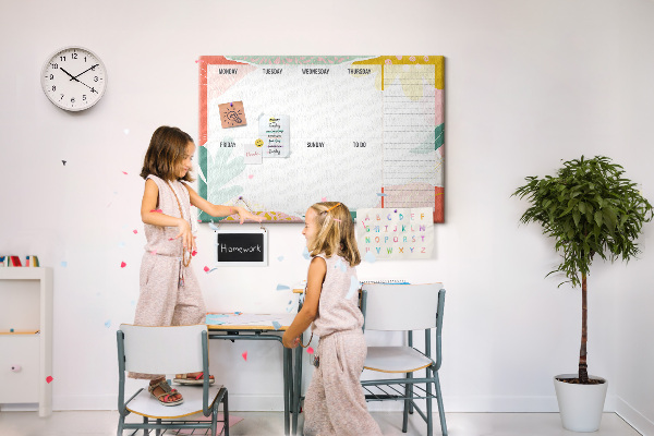 Tablero de corcho decorado con diseño de calendario floral y detalles coloridos