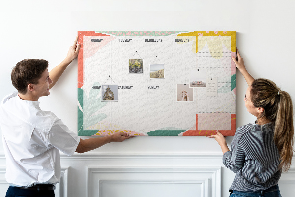 Tablero de corcho decorado con diseño de calendario floral y detalles coloridos