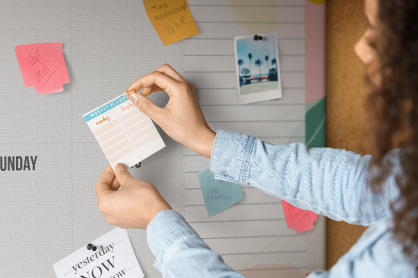 Tablero de corcho decorado con diseño de calendario floral y detalles coloridos