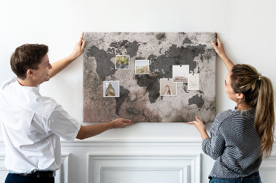 Pizarra de corcho con diseño de mapamundi oxidado sobre fondo de hormigón