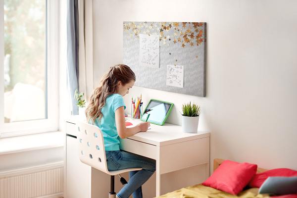 Tablero de corcho decorativo con diseño de estrellas doradas sobre fondo gris