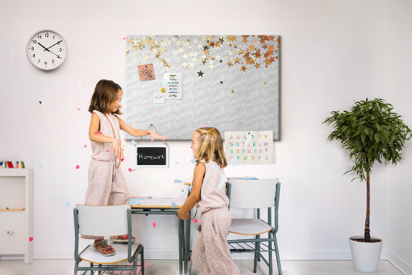 Tablero de corcho decorativo con diseño de estrellas doradas sobre fondo gris