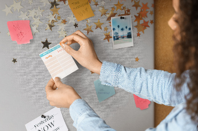 Tablero de corcho decorativo con diseño de estrellas doradas sobre fondo gris