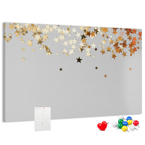 Tablero de corcho decorativo con diseño de estrellas doradas sobre fondo gris