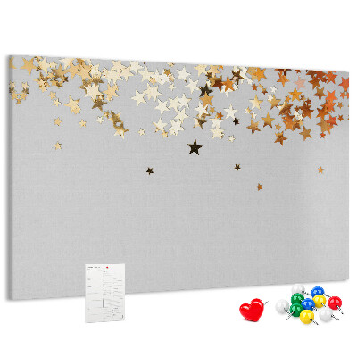 Tablero de corcho decorativo con diseño de estrellas doradas sobre fondo gris
