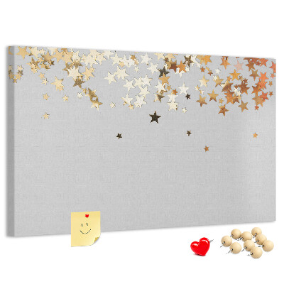 Tablero de corcho decorativo con diseño de estrellas doradas sobre fondo gris