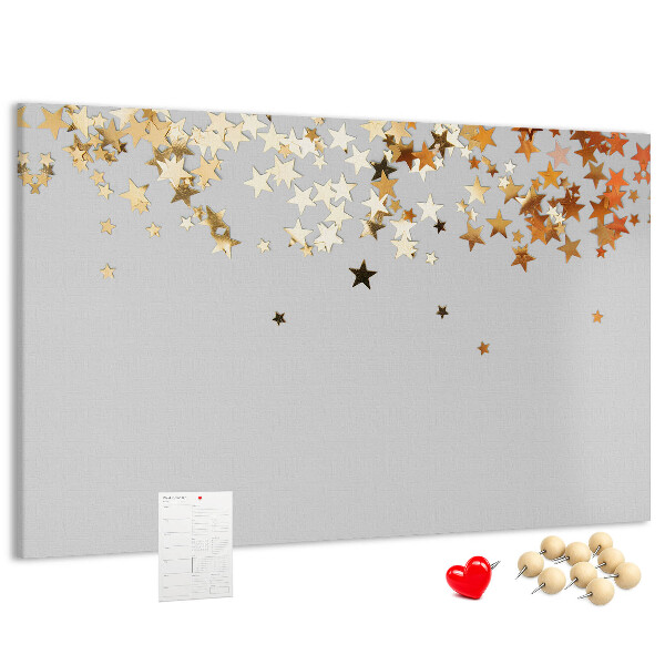 Tablero de corcho decorativo con diseño de estrellas doradas sobre fondo gris