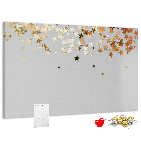Tablero de corcho decorativo con diseño de estrellas doradas sobre fondo gris
