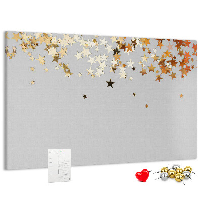 Tablero de corcho decorativo con diseño de estrellas doradas sobre fondo gris
