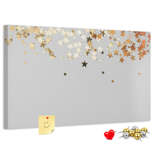 Tablero de corcho decorativo con diseño de estrellas doradas sobre fondo gris