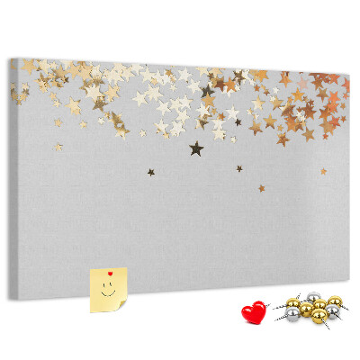 Tablero de corcho decorativo con diseño de estrellas doradas sobre fondo gris