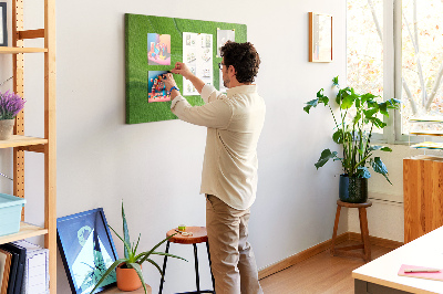Tablero de corcho decorado con diseño de ondas verdes y líneas delicadas