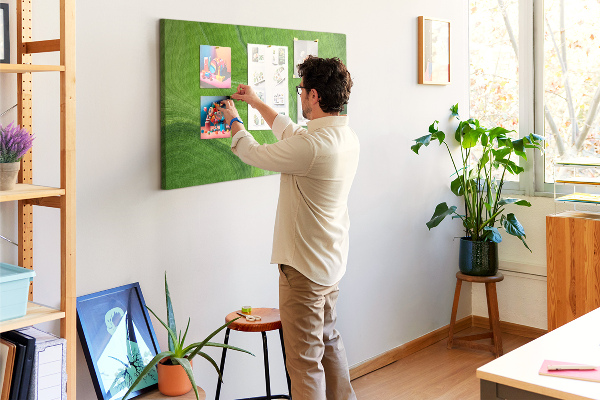 Tablero de corcho decorado con diseño de ondas verdes y líneas delicadas