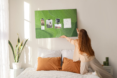 Tablero de corcho decorado con diseño de ondas verdes y líneas delicadas