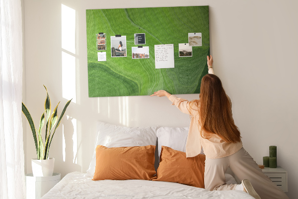 Tablero de corcho decorado con diseño de ondas verdes y líneas delicadas