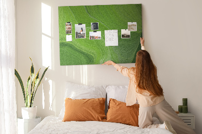 Tablero de corcho decorado con diseño de ondas verdes y líneas delicadas