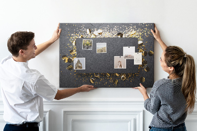 Tablero de anuncios con diseño de confeti dorado sobre fondo negro