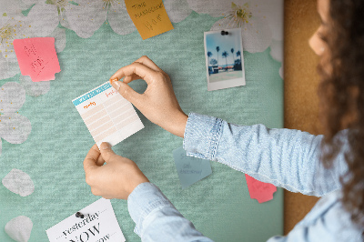 Tablero de corcho decorativo con motivos florales sobre fondo pastel