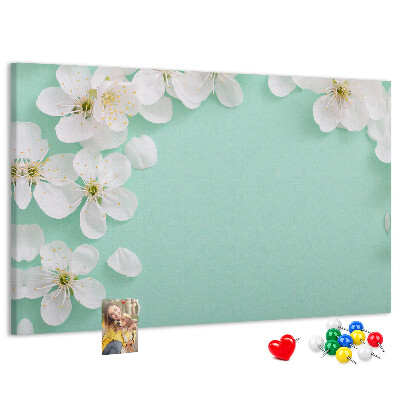 Tablero de corcho decorativo con motivos florales sobre fondo pastel