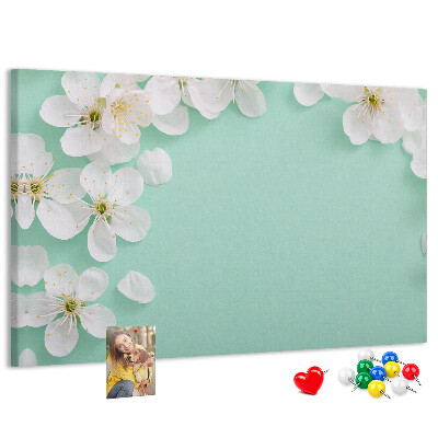 Tablero de corcho decorativo con motivos florales sobre fondo pastel