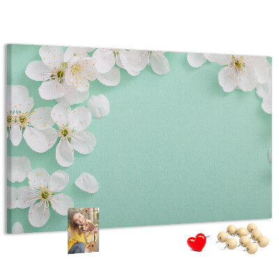 Tablero de corcho decorativo con motivos florales sobre fondo pastel