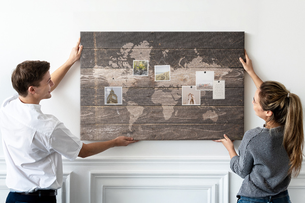 Pizarra de corcho con diseño de mapa del mundo sobre fondo de madera
