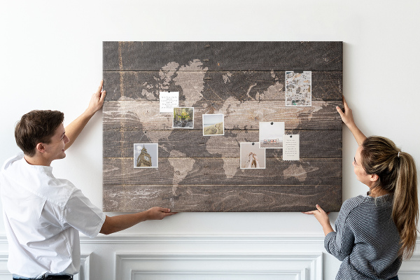 Pizarra de corcho con diseño de mapa del mundo sobre fondo de madera