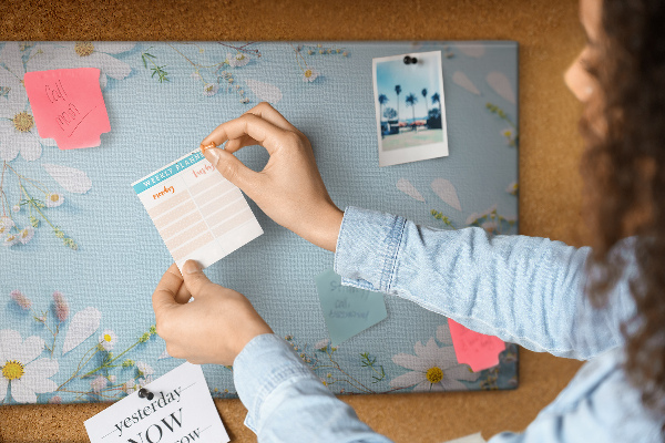 Tablero de corcho decorado con estampado floral sobre fondo azul claro