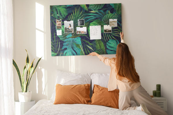 Tablero de corcho decorativo con diseño de hojas tropicales sobre fondo oscuro