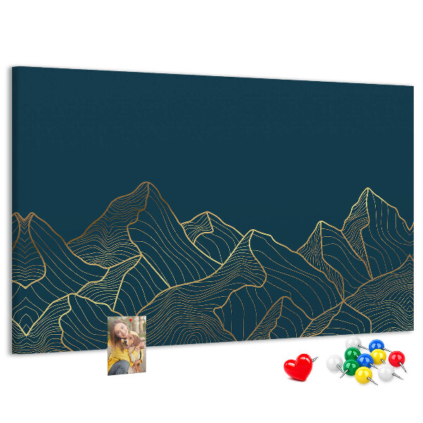 Tablero de corcho decorado con diseño de montañas en tonos dorados sobre fondo oscuro