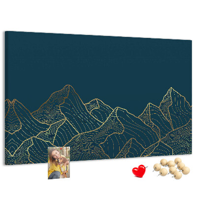 Tablero de corcho decorado con diseño de montañas en tonos dorados sobre fondo oscuro