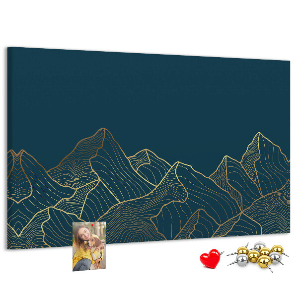 Tablero de corcho decorado con diseño de montañas en tonos dorados sobre fondo oscuro