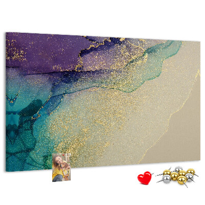 Tablero de corcho decorado con detalles dorados sobre un fondo abstracto de agua