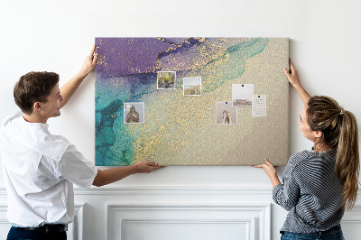 Tablero de corcho decorado con detalles dorados sobre un fondo abstracto de agua