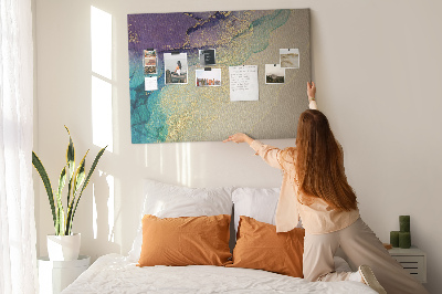 Tablero de corcho decorado con detalles dorados sobre un fondo abstracto de agua