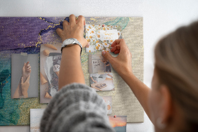 Tablero de corcho decorado con detalles dorados sobre un fondo abstracto de agua