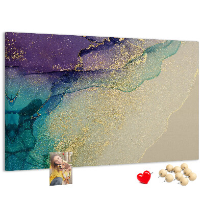 Tablero de corcho decorado con detalles dorados sobre un fondo abstracto de agua