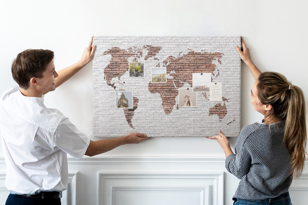 Tablero de corcho decorativo diseño de mapa del mundo sobre fondo de pared de ladrillos