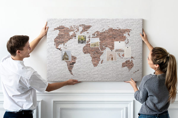 Tablero de corcho decorativo diseño de mapa del mundo sobre fondo de pared de ladrillos