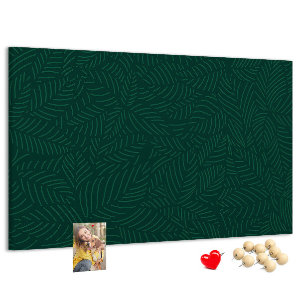 Tablero de corcho decorado hojas verdes sobre fondo oscuro