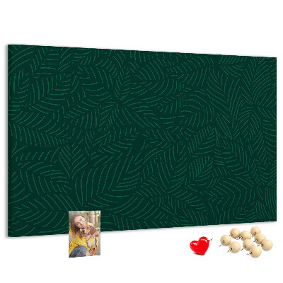 Tablero de corcho decorado hojas verdes sobre fondo oscuro