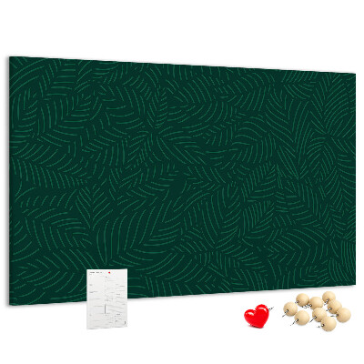 Tablero de corcho decorado hojas verdes sobre fondo oscuro