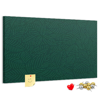 Tablero de corcho decorado hojas verdes sobre fondo oscuro