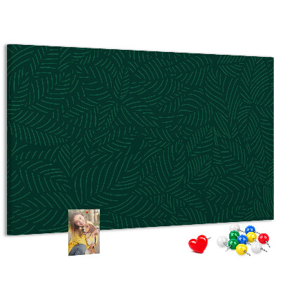 Tablero de corcho decorado hojas verdes sobre fondo oscuro