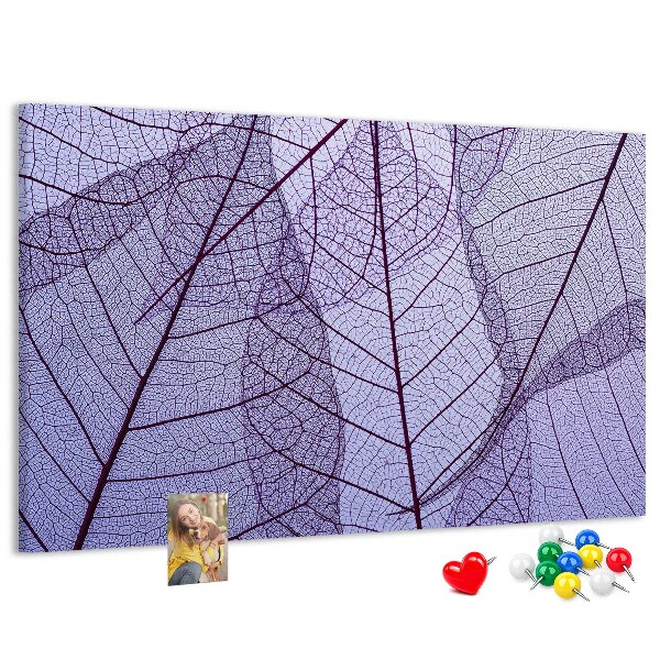 Tablero de corcho decorado con un delicado estampado de hojas sobre un fondo morado