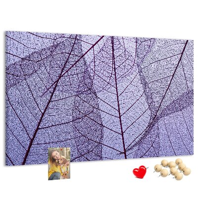 Tablero de corcho decorado con un delicado estampado de hojas sobre un fondo morado